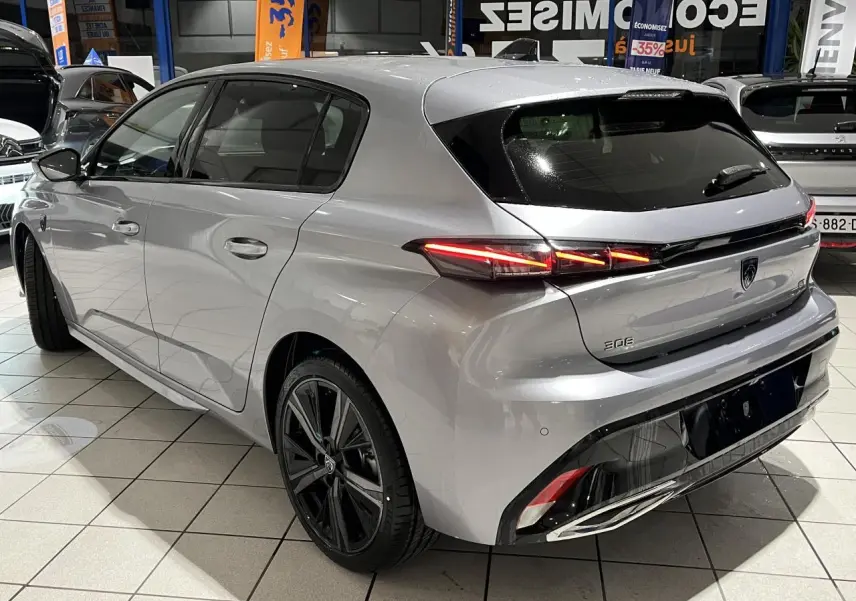 Vue 3/4 arrière droite de la Peugeot 308 2024 gris Artense avec feux arrière LED et jantes alliage 18 pouces noires.
