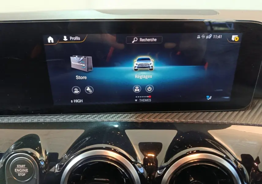 Écran tactile central du tableau de bord de la Mercedes Classe A 250 e Business Line bleu, avec commandes et bouton start/stop visibles.