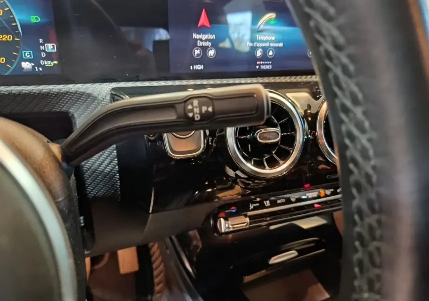 Gros plan sur la commande de boîte automatique et tableau de bord noir brillant de la Mercedes Classe A bleu hybride rechargeable.