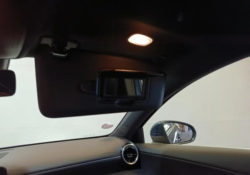 Vue intérieure côté droit de la Mercedes Classe A 250 e Business Line 2021, avec pare-soleil ouvert et rétroviseur bleu visible.