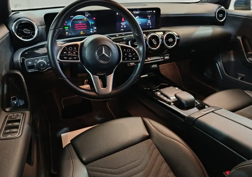 Vue intérieure avant de la Mercedes Classe A 250 e Business Line 2021, volant cuir multifonctions et écran tactile large.