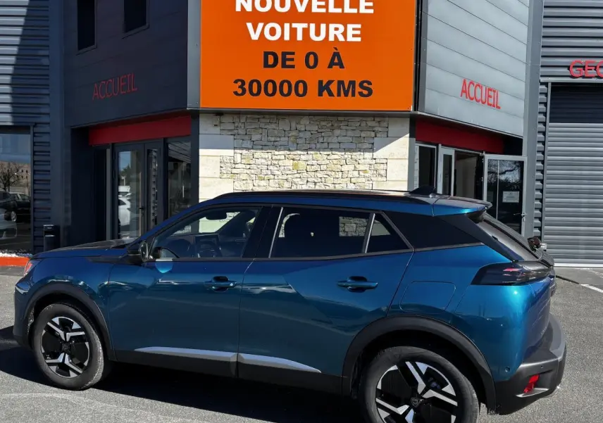 Vue de profil côté gauche d’un Peugeot 2008 Hybrid 145 bleu 2025 avec toit noir et jantes distinctives.