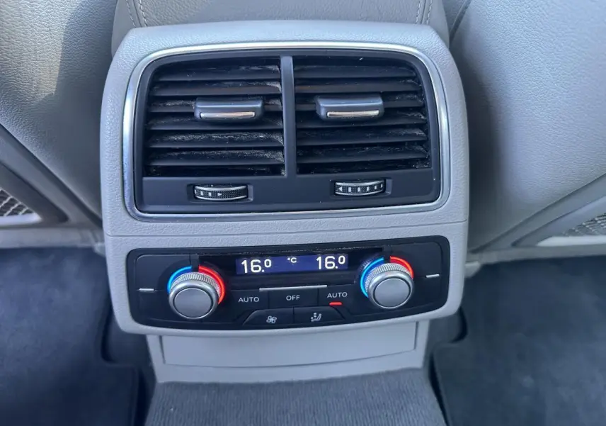 Gros plan sur la commande de climatisation automatique arrière bi-zone de l'Audi A6 gris, avec réglages à 16°C.