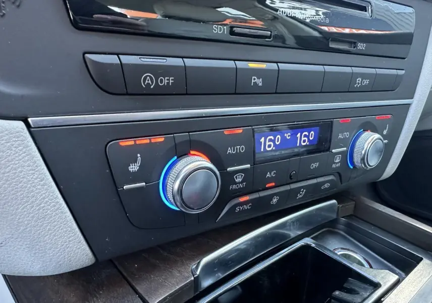 Détail de la console centrale de l’Audi A6 2015 montrant la climatisation automatique 4 zones avec réglages à 16°C.