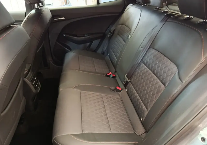 Vue intérieure côté droit sur la banquette arrière en cuir noir avec surpiqûres rouges du MG3 2024 gris foncé.