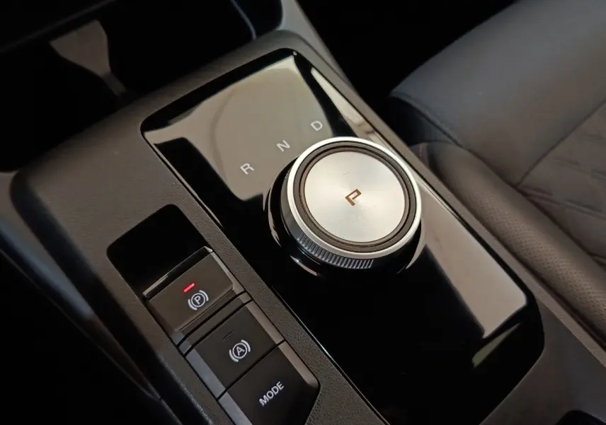 Gros plan sur la molette de boîte automatique et commandes noires du levier de vitesses intérieur d’une MG3 gris foncé.