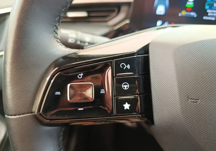 Gros plan sur les commandes multifonctions noires du volant côté gauche du MG3 gris foncé 2024.