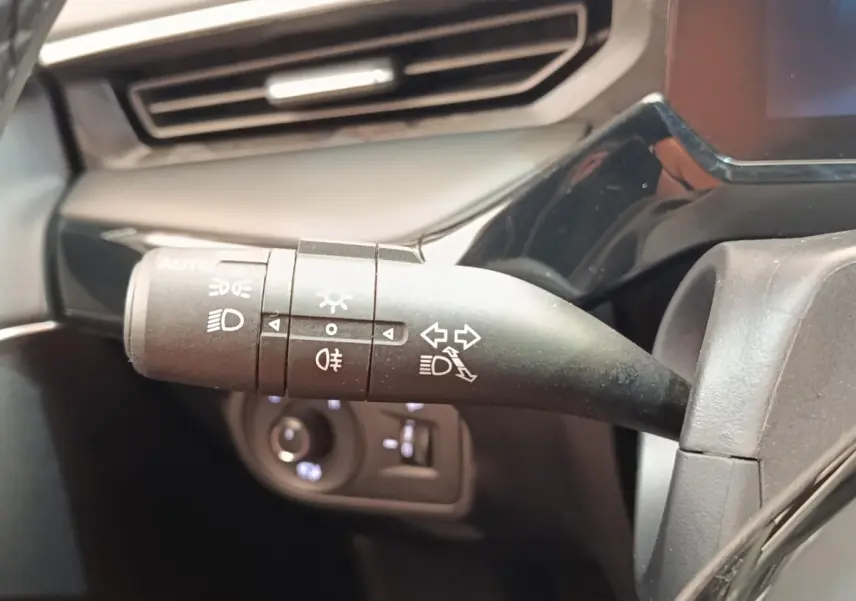 Gros plan sur la commande des phares et clignotants du MG3 1.5L Hybrid+ Luxury, intérieur noir et gris.