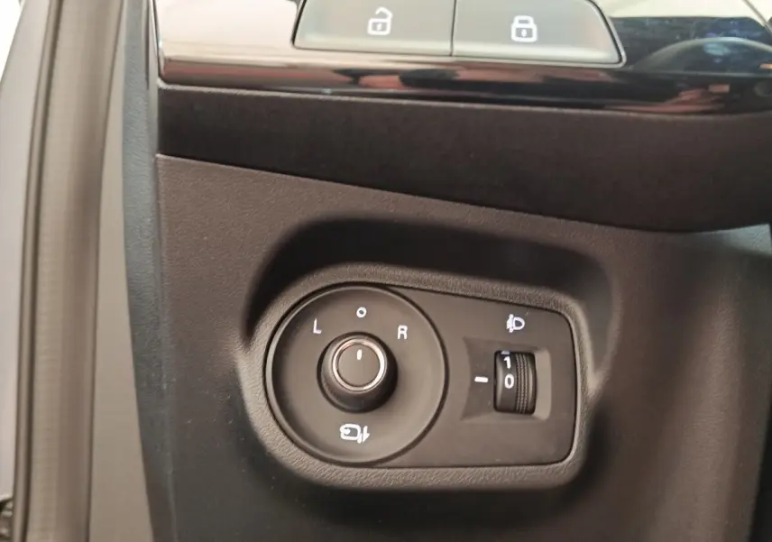 Commande de réglage des rétroviseurs et des phares sur le panneau intérieur côté conducteur d'une MG3 gris foncé 2024.