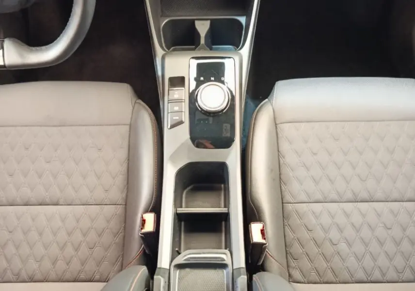 Vue plongeante sur la console centrale et les sièges gris foncé avec surpiqûres orange du MG3 2024 Hybrid+ Luxury.