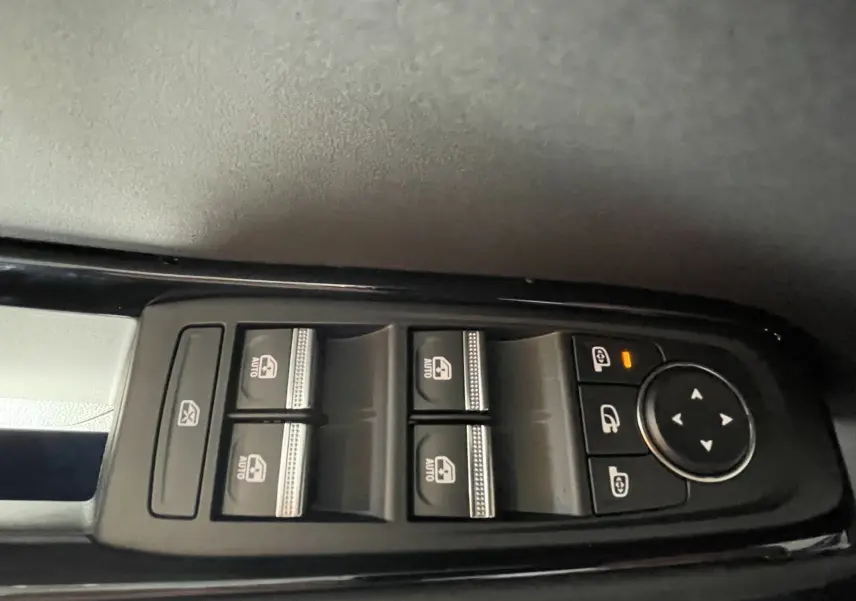 Gros plan sur les commandes de lève-vitres et réglages des rétroviseurs côté conducteur du Renault Rafale gris shiste 2024.