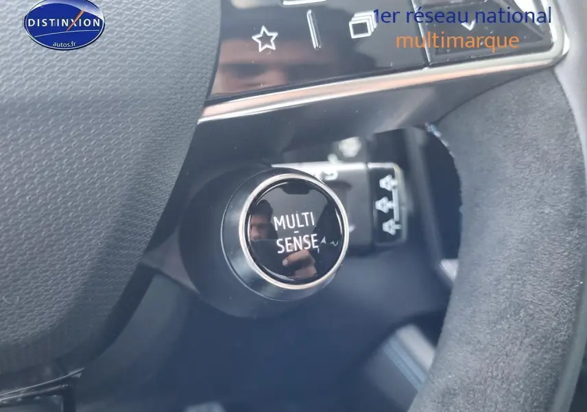 Gros plan sur le bouton Multi Sense dans l'habitacle du Renault Rafale bleu sommet, côté conducteur.