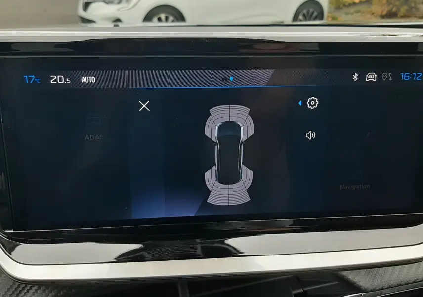 Affichage du système d'aide au stationnement sur l'écran central d'un Peugeot 2008 gris Artense, vue intérieure.