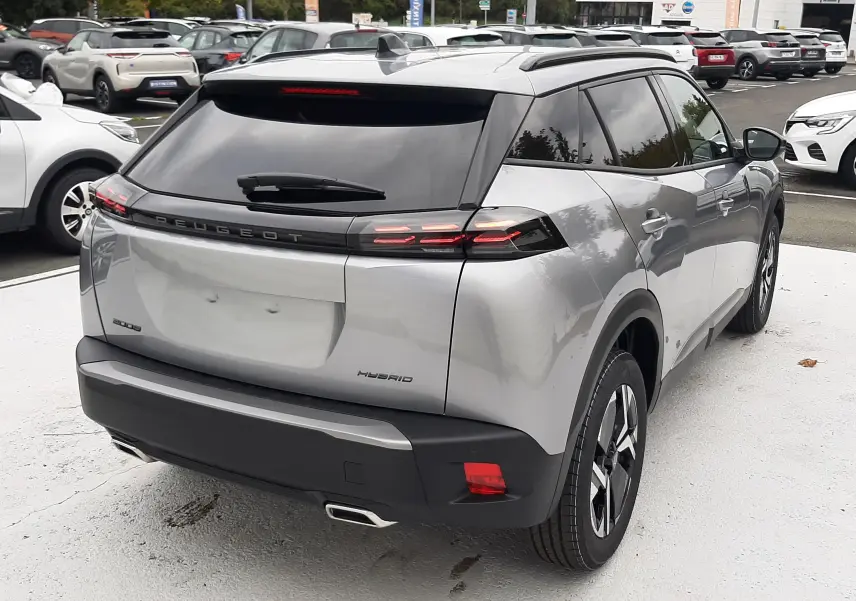 Vue 3/4 arrière droite d'un Peugeot 2008 gris Artense hybride avec feux arrière LED et toit noir contrasté.