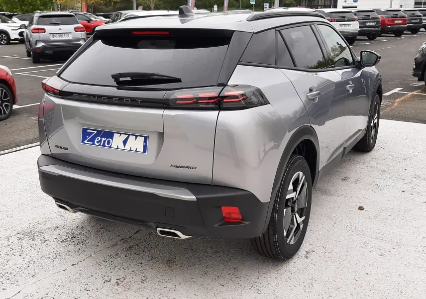 Vue 3/4 arrière droite du Peugeot 2008 hybride gris Artense avec feux arrière LED et toit noir contrasté.
