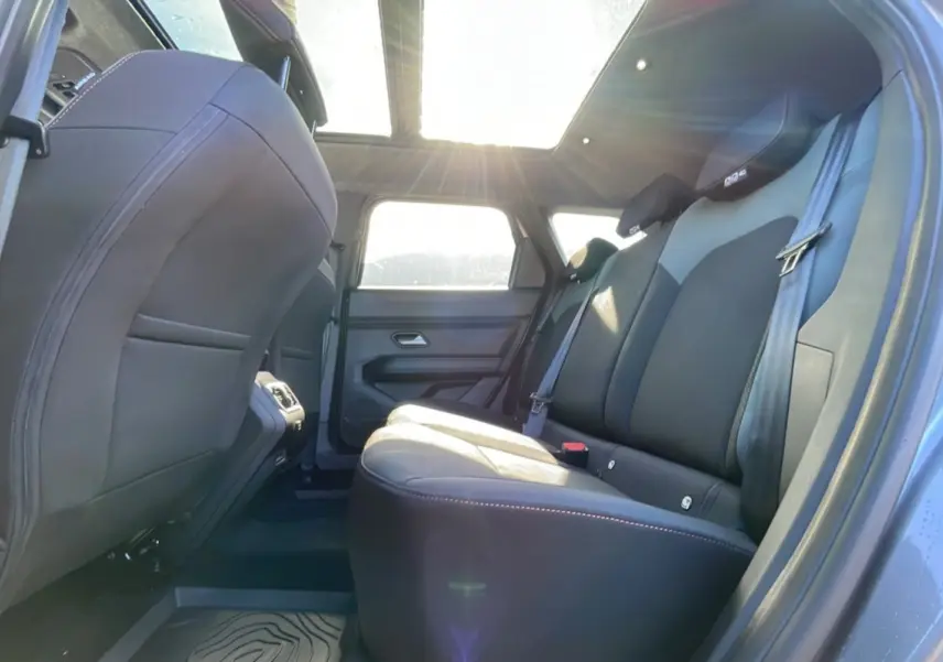 Vue intérieure arrière côté droit du Dacia Bigster 2025 gris schiste, avec sièges en cuir et toit panoramique lumineux.