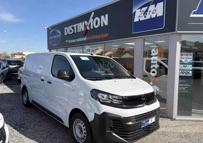 Opel Vivaro blanc vu en 3/4 avant droit, avec calandre noire et pare-chocs avant massif noir mat.