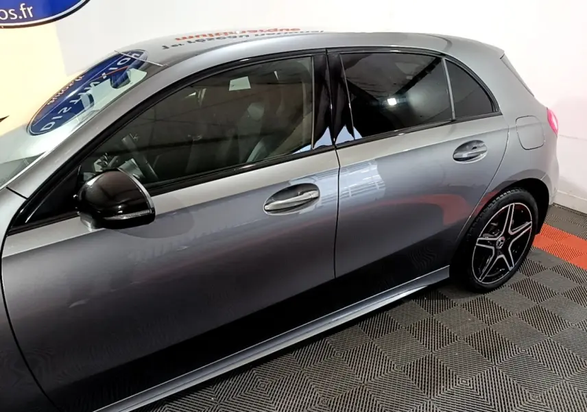 Vue latérale droite d'une Mercedes Classe A 250 e AMG Line gris foncé avec jantes noires et rétroviseur noir brillant.