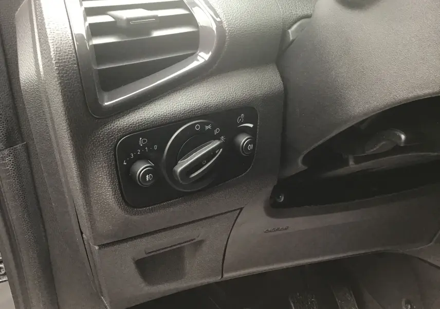 Détail du tableau de bord côté gauche du Ford EcoSport gris foncé, montrant les commandes d’éclairage et la ventilation.