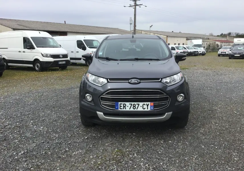 Vue de face d'un Ford EcoSport gris foncé métal, avec calandre chromée et plaque d'immatriculation française visible.