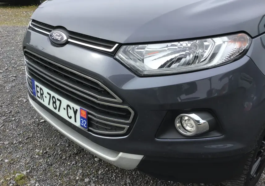 Vue de près 3/4 avant droit du Ford EcoSport gris foncé métallisé, mettant en valeur la calandre et le phare avant.