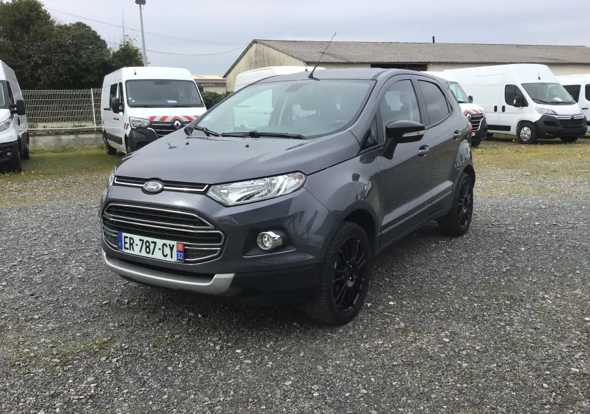 Ford Ecosport gris foncé métal vu en 3/4 avant droit, avec jantes noires et calandre chromée sur parking extérieur.