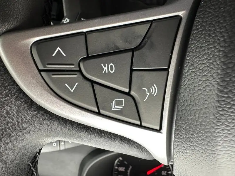 Gros plan sur les commandes noires du volant côté gauche du Dacia Jogger brun Terracota 2024.