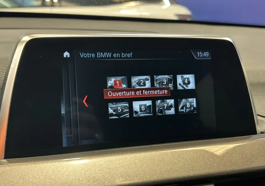 Écran central de la BMW X1 blanc 2018 montrant le menu "Ouverture et fermeture" du système multimédia.