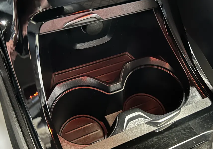 Gros plan sur les porte-gobelets noirs intégrés à la console centrale du BMW X1 blanc sDrive18iA 2018.