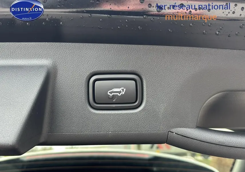 Bouton d'ouverture électrique du hayon sur intérieur noir du Hyundai Tucson 2026 vue rapprochée du coffre ouvert.