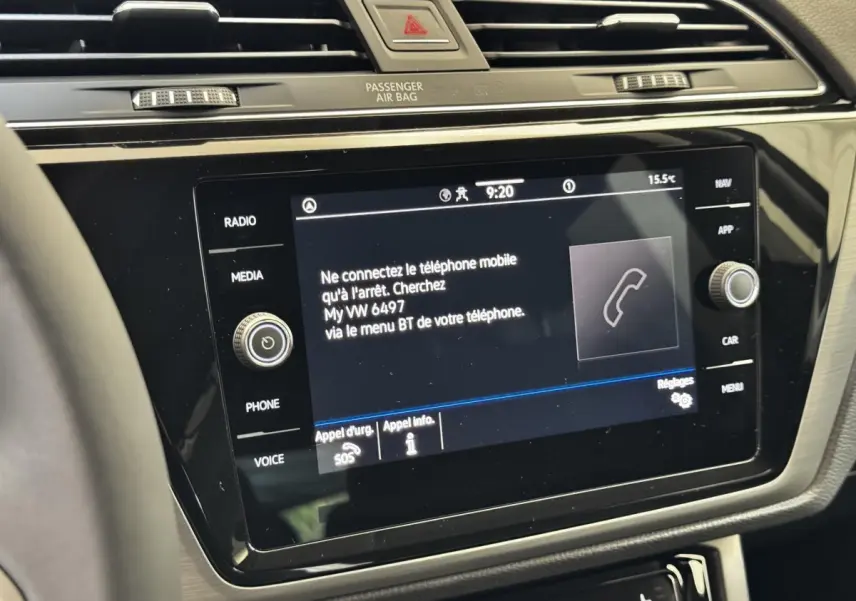 Gros plan sur l'écran tactile central noir du tableau de bord du Volkswagen Touran 2024 avec commandes autour.