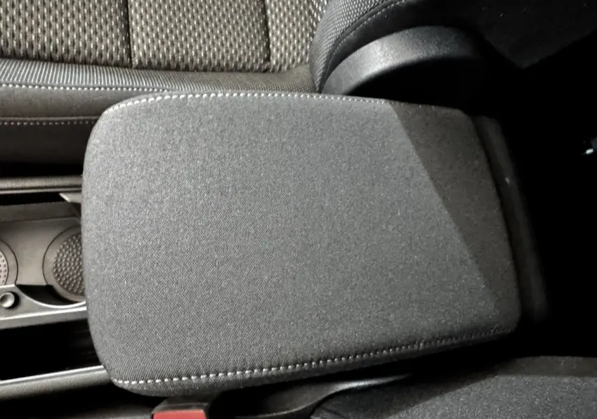 Gros plan sur l'accoudoir central tissu gris et les sièges arrière en tissu du Volkswagen Touran 2024.