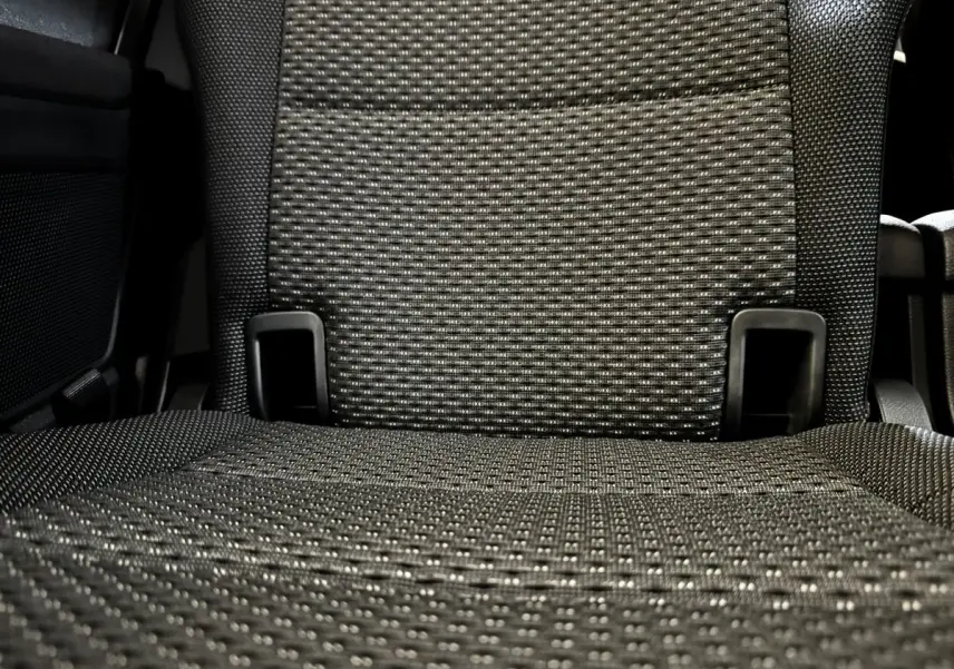 Gros plan sur le tissu gris texturé d’un siège arrière individuel du Volkswagen Touran 2024, version 7 places.