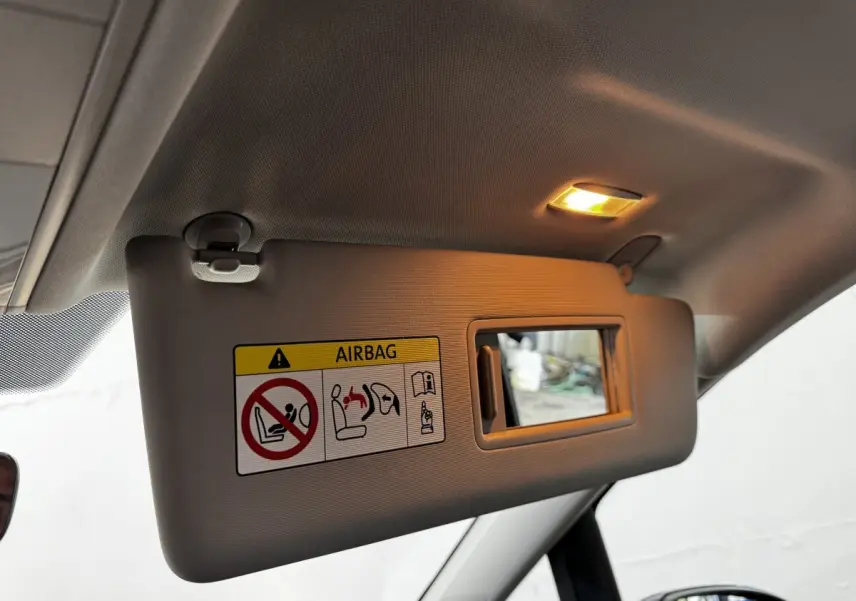 Détail du pare-soleil côté conducteur avec miroir éclairé dans un Volkswagen Touran bleu 2024.