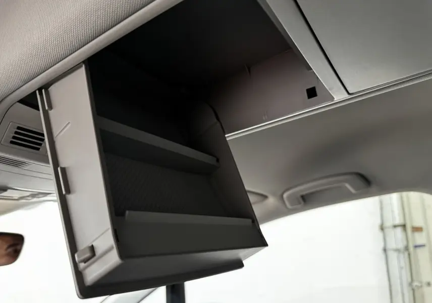 Rangement plafond ouvert dans l'habitacle d'un Volkswagen Touran 2024, vue intérieure en léger contre-plongée.