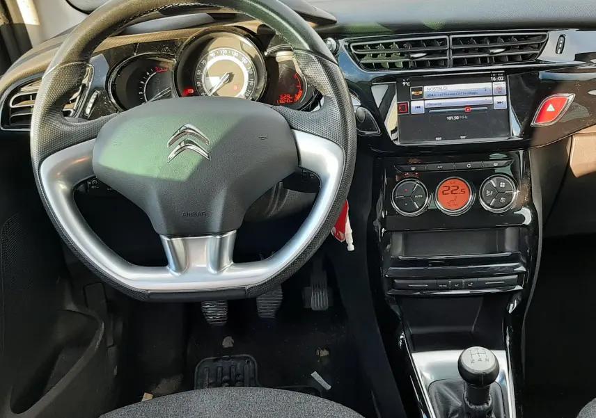 Vue intérieure du tableau de bord et volant Citroën C3 BlueHDi 75 Exclusive 2016 avec console centrale brillante et levier de vitesse manuel.