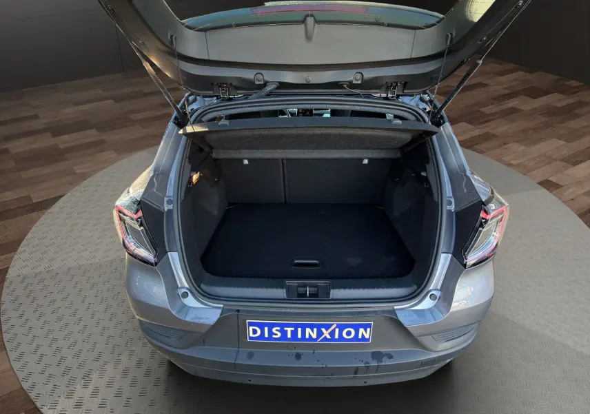 Vue arrière du Renault Captur 2024 gris Cassiopée avec toit noir, coffre ouvert et plaque Distinxion visible.