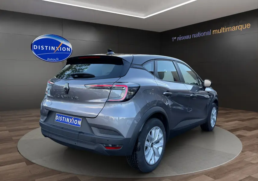 Renault Captur 2024 gris Cassiopée avec toit noir, vue 3/4 arrière droit, finition Evolution avec caméra.