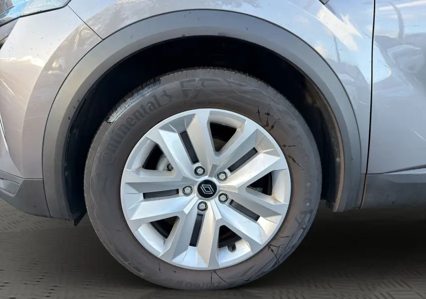 Gros plan sur la roue avant gauche du Renault Captur gris Cassiopée avec jante alliage et peinture bi-ton toit noir.