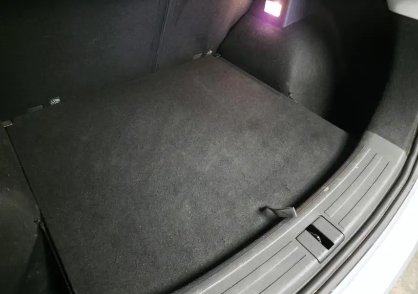 Coffre ouvert de MG ZS 2023, vue intérieure montrant le tapis noir et l’éclairage du coffre allumé.
