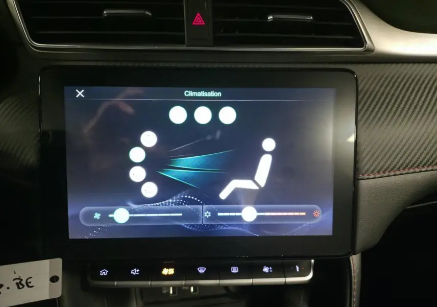 Écran tactile central de la MG ZS gris 2023 affichant le réglage de la climatisation, entouré de garnitures noires et carbone.