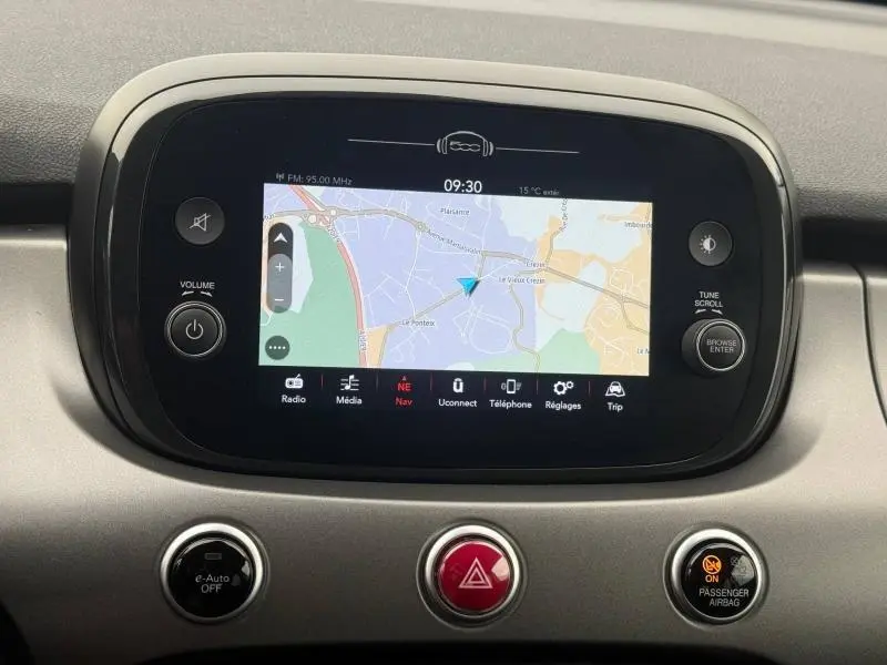 Écran tactile central de la FIAT 500X 2024 affichant la navigation, entouré de commandes et boutons de tableau de bord.