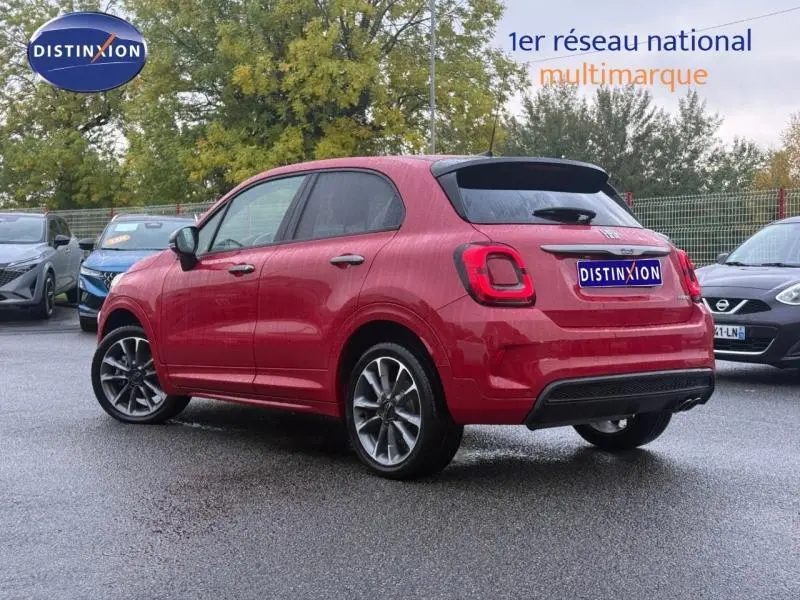Fiat 500X rouge Passione pastel vue 3/4 arrière droit, mettant en valeur ses feux arrière et jantes alliage.