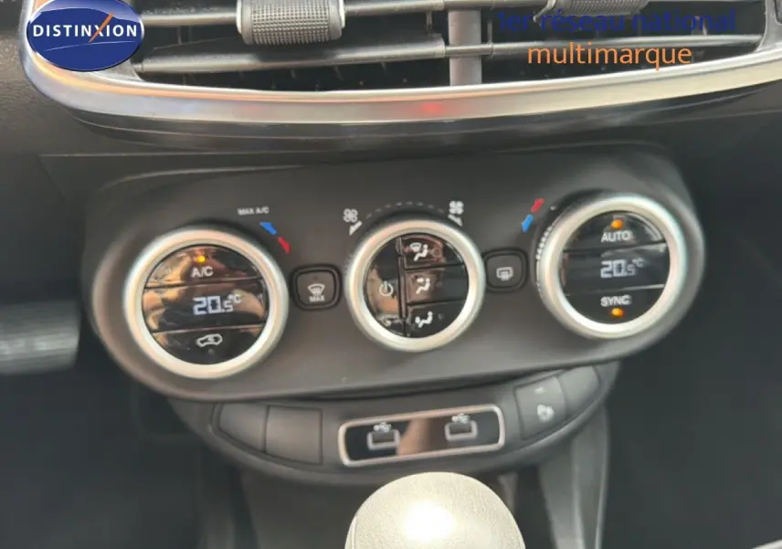 Gros plan sur la console centrale de la Fiat 500X 2024, montrant les commandes de climatisation digitales et la boîte automatique.