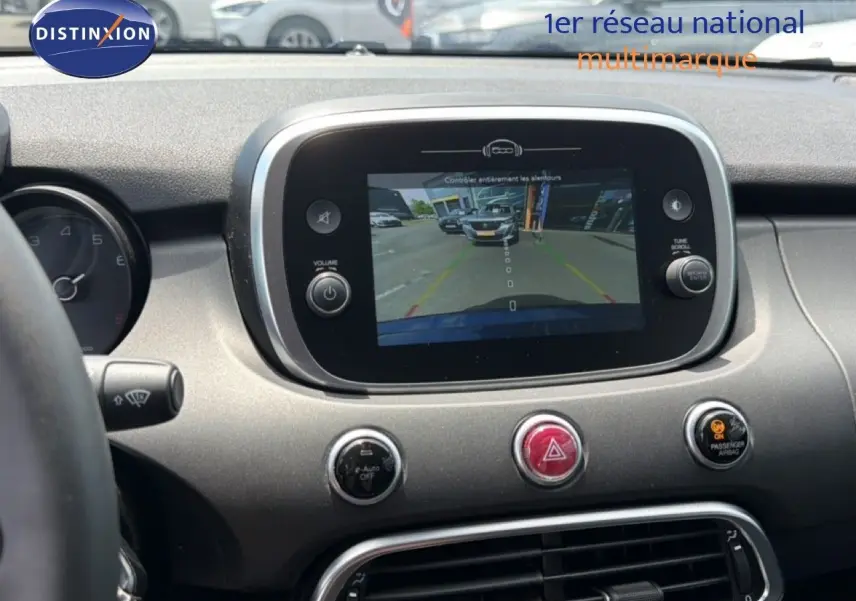 Vue rapprochée de l’écran central et tableau de bord du Fiat 500X 2024, affichant la caméra de recul.