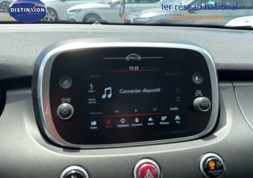 Écran tactile central de la console d’une Fiat 500X 2024, affichant l’interface multimédia avec option connecter dispositif.