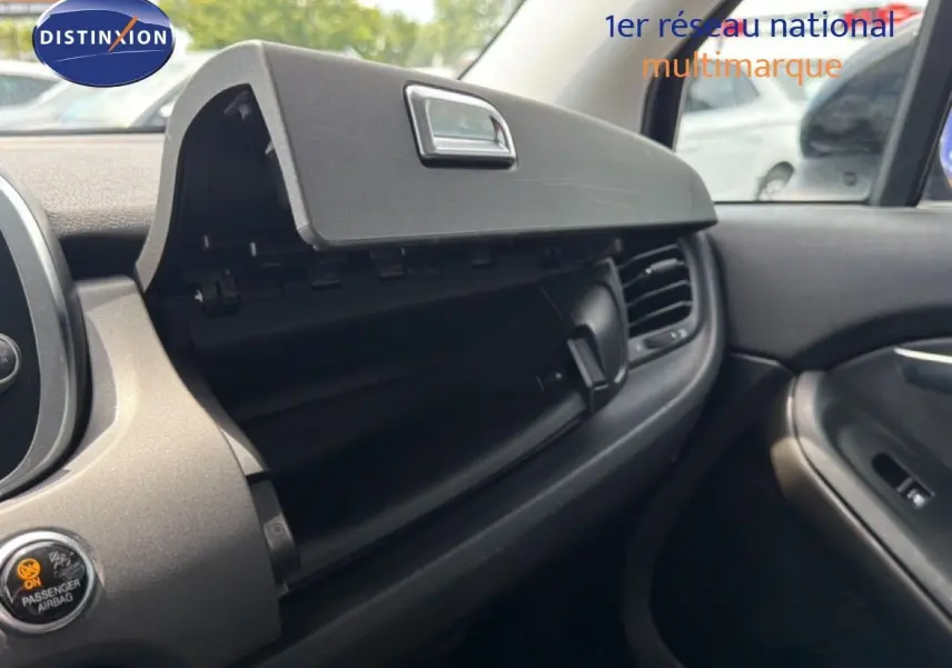Intérieur de la FIAT 500X 2024 montrant la boîte à gants ouverte côté passager avec tableau de bord noir.