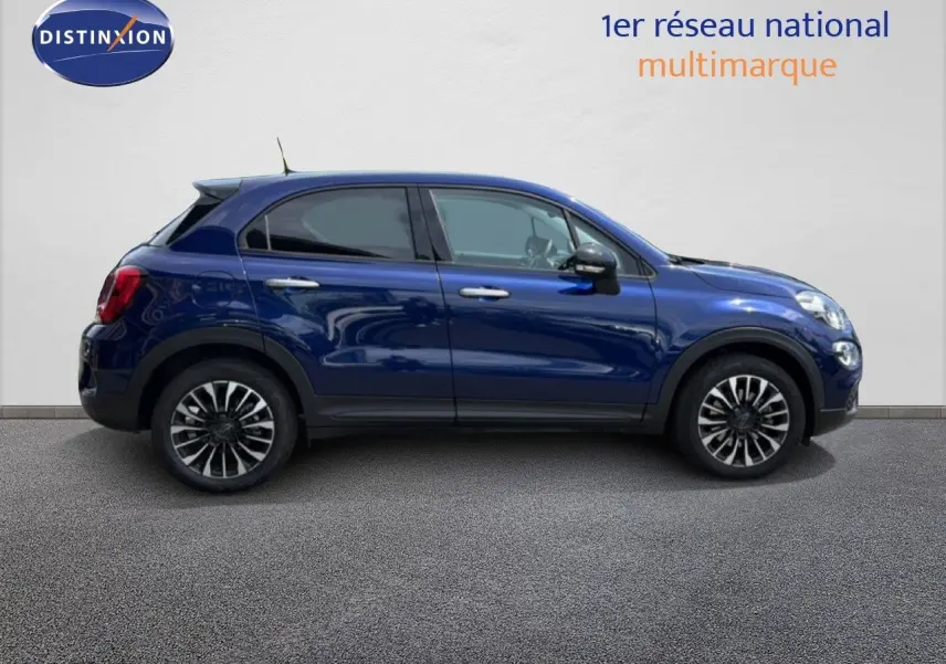 Vue de profil côté gauche d'une FIAT 500X 2024 bleu Venezia avec jantes alliage bi-ton et vitres teintées.
