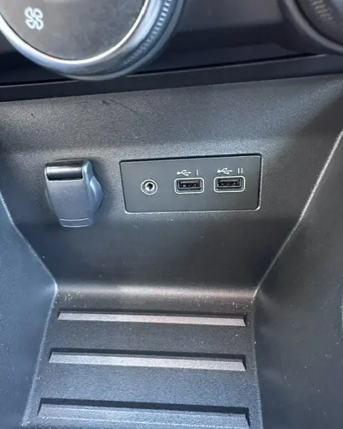 Gros plan sur la console centrale noire de la Renault Clio V Blue dCi 2025, montrant deux ports USB et une prise 12V.