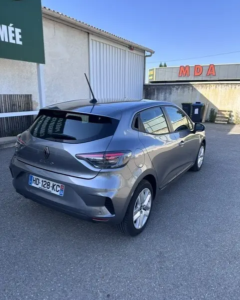 Vue 3/4 arrière droite d'une Renault Clio gris métallisé 2025 avec vitres surteintées et feux arrière LED.